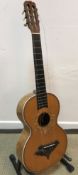 An early 20th Century acoustic guitar with mother of pearl inlaid floral decoration and birds eye