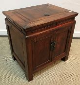 A 19th Century Chinese elm dwarf cupboard, the top with rising compartment over two panelled doors,