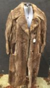 A ladies fur coat with leather tim