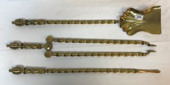 A set of three Victorian brass barley twist shafted fire irons with lidded urn shaped finials,