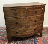 An early 19th Century mahogany bow fronted chest of two short over two long drawers on splayed