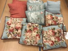 A box containing a large collection of assorted scatter cushions