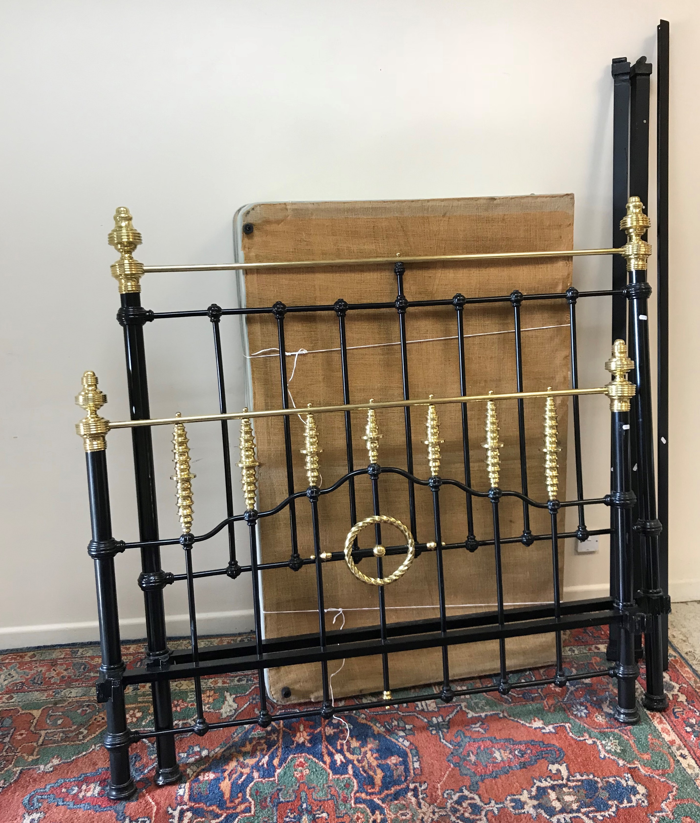 A Victorian style black painted and brass double bedstead with bobbin decorated column decoration