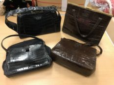 Four mid 20th Century crocodile skin handbags each bearing initial