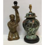 A 20th Century Chinese glazed terracotta figural table lamp as a woman kneeling holding aloft a