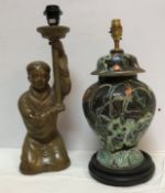 A 20th Century Chinese glazed terracotta figural table lamp as a woman kneeling holding aloft a