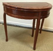 A modern Indian rosewood foldover tea table of demi lune form on shallow moulded cabriole legs 91