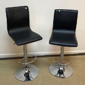 Two modern faux leather covered and chrome based bar stools