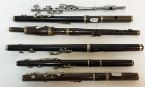 A collection of various woodwind instruments including a silver plated three section flute stamped