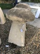 A stone topped staddle with weathered composite stone base