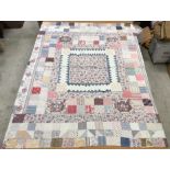 A 19th Century patchwork quilt in pink, blue and white,