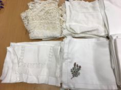 A holdall containing various lace and linen wares to include napkins, tablecloths, runners,