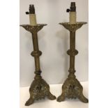 A pair of 19th Century pierced brass candlesticks converted to electricity, with painted highlights,