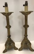 A pair of 19th Century pierced brass candlesticks converted to electricity, with painted highlights,