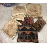 A box containing assorted scatter cushions to include two carpet examples,