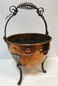 A Victorian embossed copper coal bucket with scrollwork decorated wrought iron handle raised on