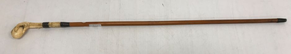 A circa 1900 walking cane with ivory handle in the form of a claw clutching an egg,