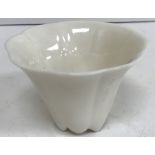 A Chinese blanc de chine wine cup of ribbed design with prunus blossom relief work decoration,
