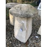 A stone topped staddle stone with weathered composite stone base