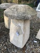 A stone topped staddle stone with weathered composite stone base