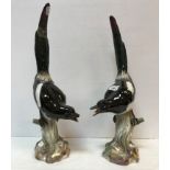 A pair of 19th Century Meissen figures of "Magpies upon mossy stumps",