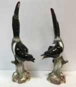 A pair of 19th Century Meissen figures of "Magpies upon mossy stumps",