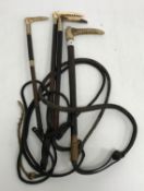 A collection of four antler handled riding crops each with metal ferrule and leather shaft and