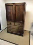 A Victorian mahogany linen press (marriage) the plain top of two sliding cupboard doors above a
