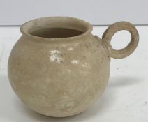 A Chinese buff glazed tea bowl of cauldron form with ring handle, 5.