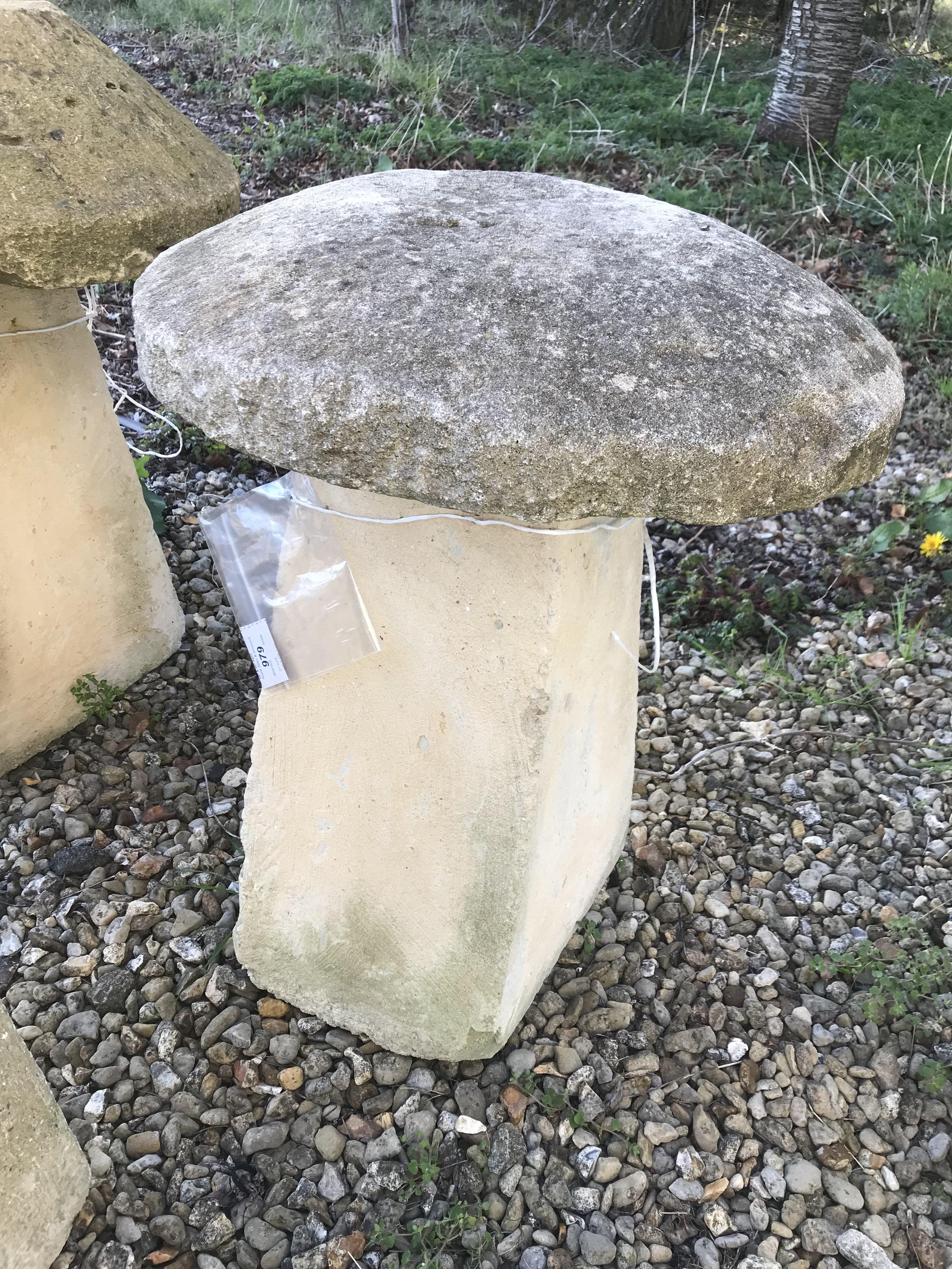 A stone topped staddle stone with weathered composite stone base