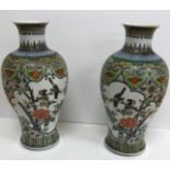 A pair of 19th Century Chinese polychrome decorated baluster shaped vases decorated with panels of