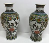 A pair of 19th Century Chinese polychrome decorated baluster shaped vases decorated with panels of