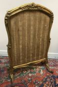 A 19th Century carved giltwood framed adjustable fire screen formerly with silkwork panels,