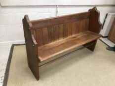 A stained pitch pine two seat pew of typical form with Gothic style ends,