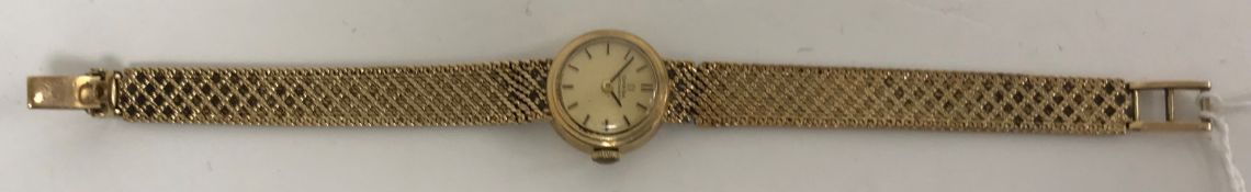 An Omega ladies wristwatch, the brushed dial set with markers on a 9 carat gold strap,