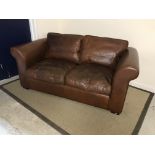 A Laura Ashley "Burgess" brown leather covered two seat sofa,