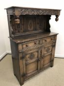 An oak court cupboard attributed to Titchmarsh & Goodwin in the Lake District style,