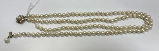 A twin strand pearl necklace with 9 carat gold and diamond set clasp,