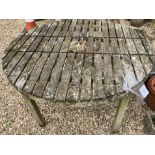 A weathered teak circular garden table,