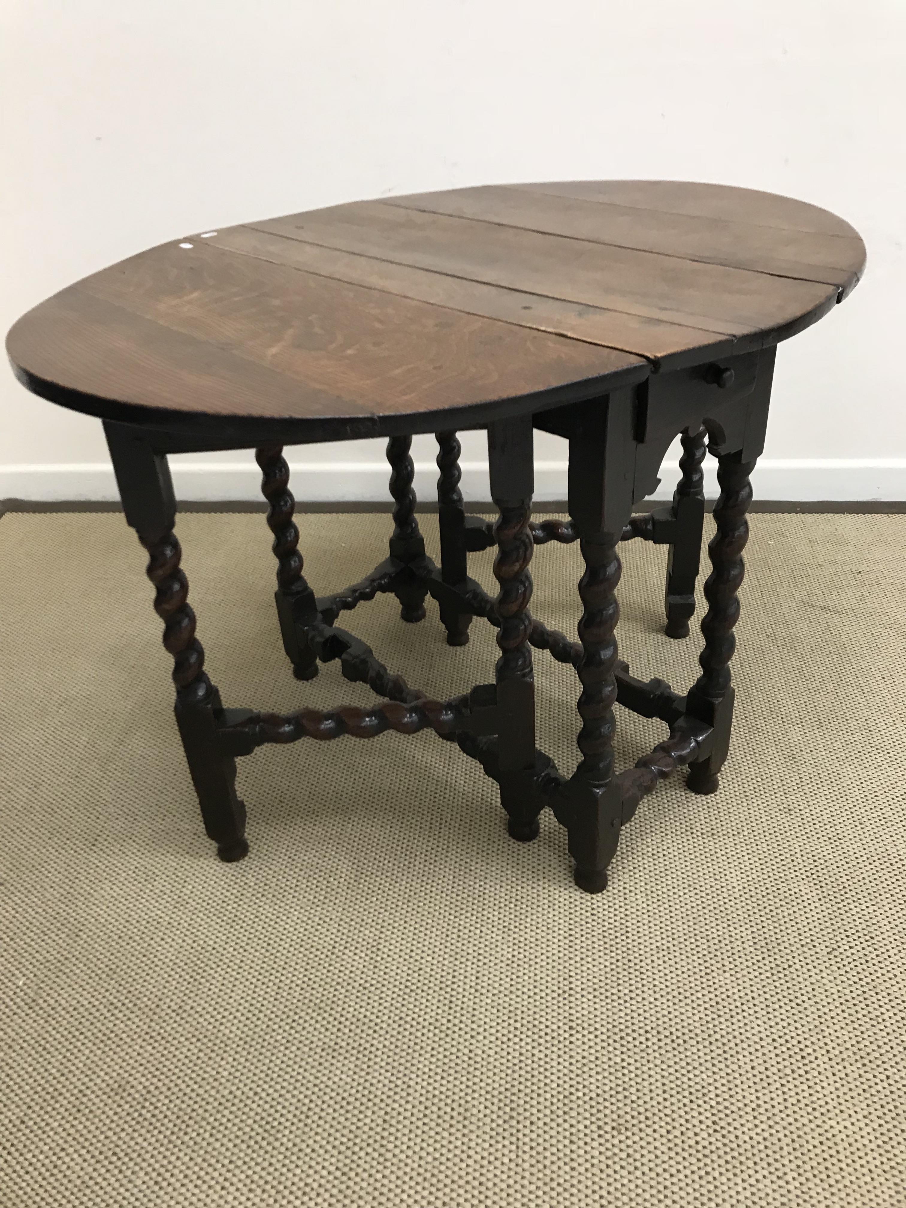 An 18th Century oak oval gate-leg drop-leaf dining table on barley-twist supports united by - Image 2 of 3