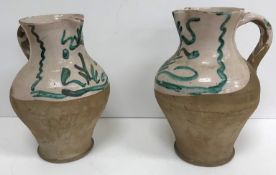 WITHDRAWN A pair of 19th Century part glazed terracotta baluster shaped jugs with scrolling foliate