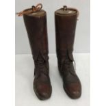 A box containing a pair of brown leather polo boots with wooden trees,