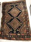 An Afshar rug, the central panel set with two repeating diamond shaped medallions on a blue ground,