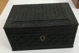 A circa 1900 carved ebony box of rectangular form with all over floral lozenge medallion decoration