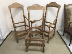 A pair of modern elbow chair frames with scroll finials and carved decoration,