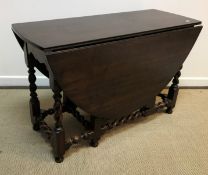 An oak oval gate leg drop leaf dining table on barley twist supports in the 17th Century style 121