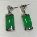 A pair of modern white metal mounted jade drop earrings with script decorated mounts,