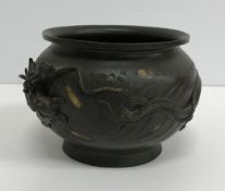 An early 20th Century Japanese bronze vase with relief work dragon decoration raised on a circular