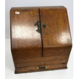 A late Victorian oak slope front stationery cabinet by Parkins & Gotto of Oxford Street,