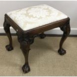 An early 20th Century walnut framed dressing stool in the Georgian style raised on shell carved